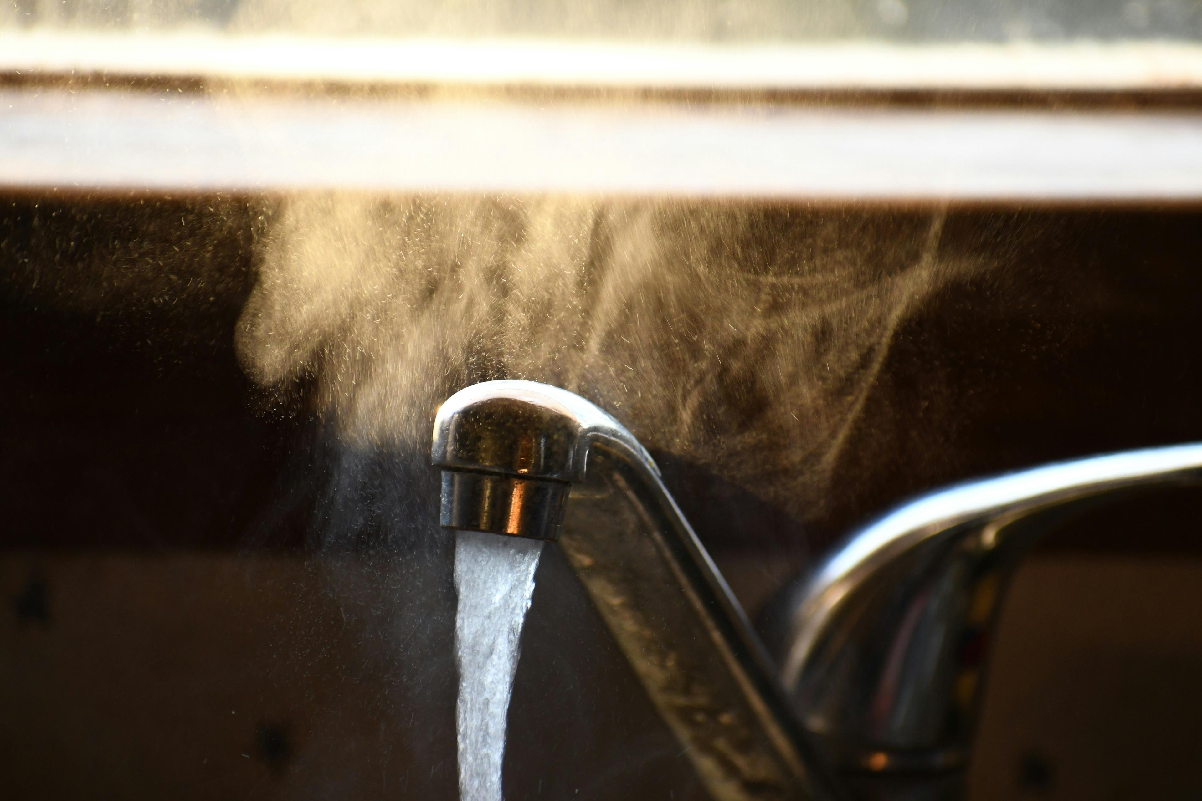 Hot water flowing from sink faucet